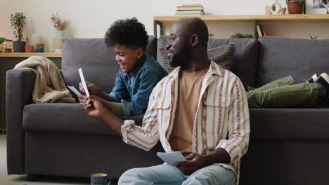 Man-and-boy-looking-at-pictures-at-home