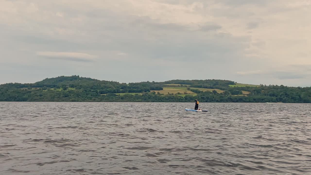 joven remando en la orilla del lago lomond