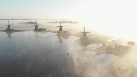 Holländische-Windmühlen,-Umgeben-Von-Tiefem-Nebel,-Zu-Einer-Epischen-Goldenen-Stunde-An-Der-Zaanse-Schans,-Filmische-Drohnenaufnahme-In-4K