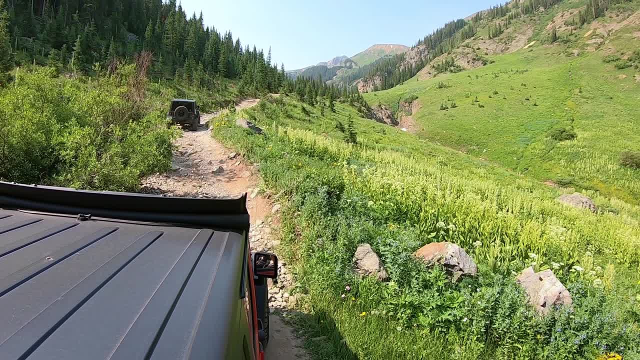 un vehículo todoterreno en una empinada pradera alpina en el sendero circular alpino en el interior de las montañas de san juan cerca de la ciudad del lago, colorado