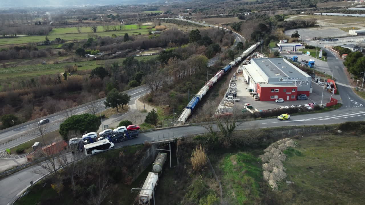 Aerial View of Train Crossing Highway and Countryside
