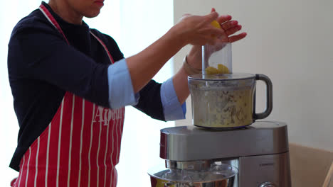 woman used electric food processor to chop potatoes in the kitchen