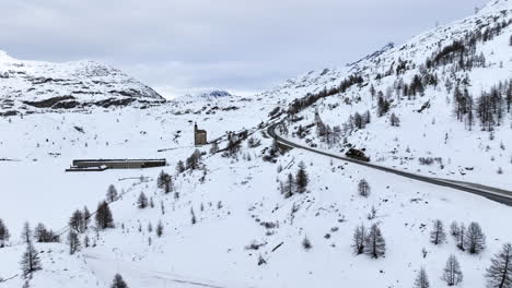 Carretera-Asfaltada-Negra-Que-Sube-Por-El-Paso-Simplón-Cubierto-De-Nieve-En-Un-Día-Nublado