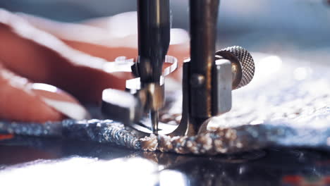 hand on old sewing machine. seamstress making new clothing concept