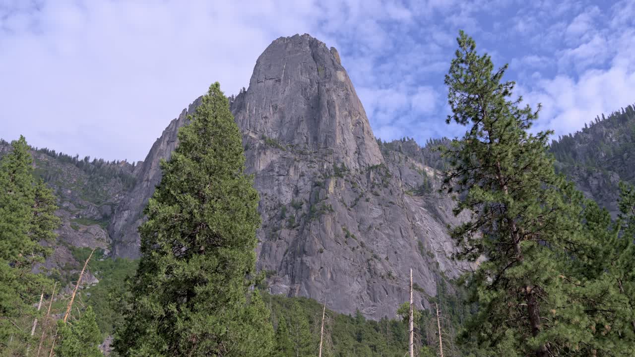 Footage showing clouds slowly passing over massive granite rock formations in Yosemite National Park, California.