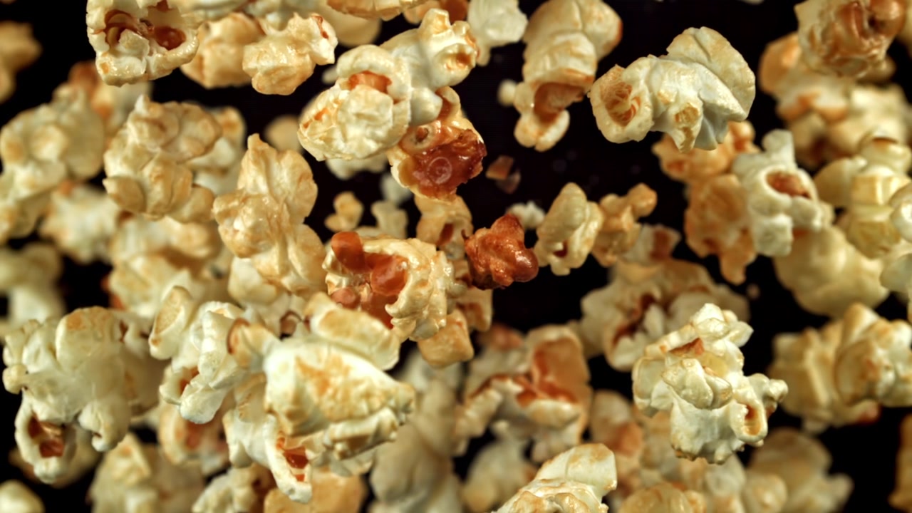 Close-Up of Popcorn Falling in Slow Motion on Black Background