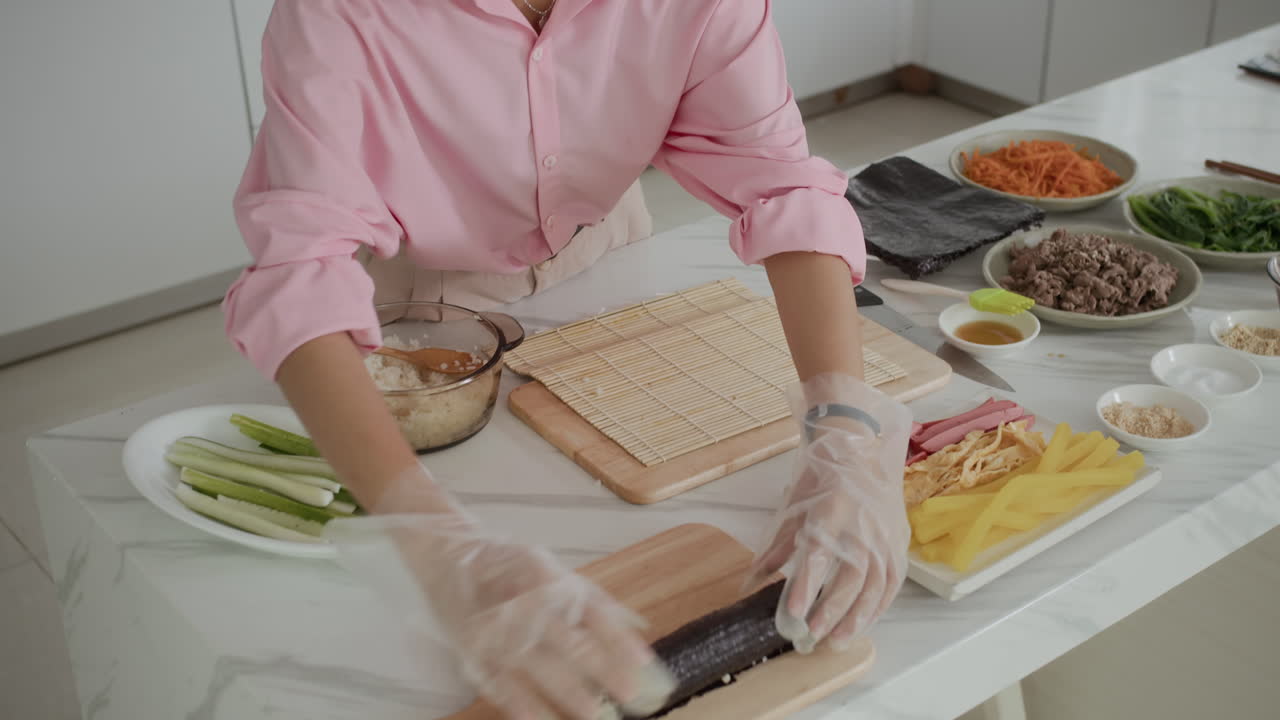 Woman Cooking Sushi from Nori, Rice and Vegetables at Home Kitchen