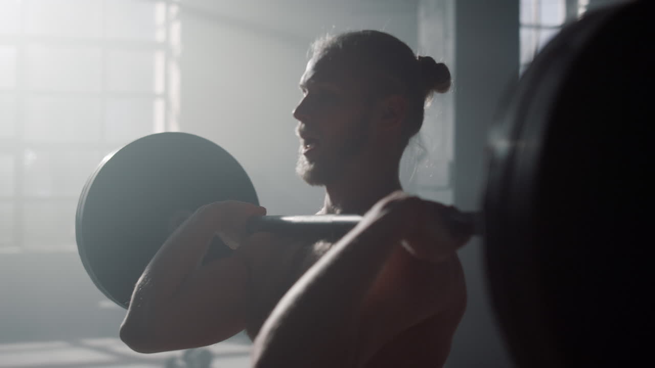 Uomo che solleva pesi durante l'allenamento. Bodybuilder che esegue esercizi con bilanciere.