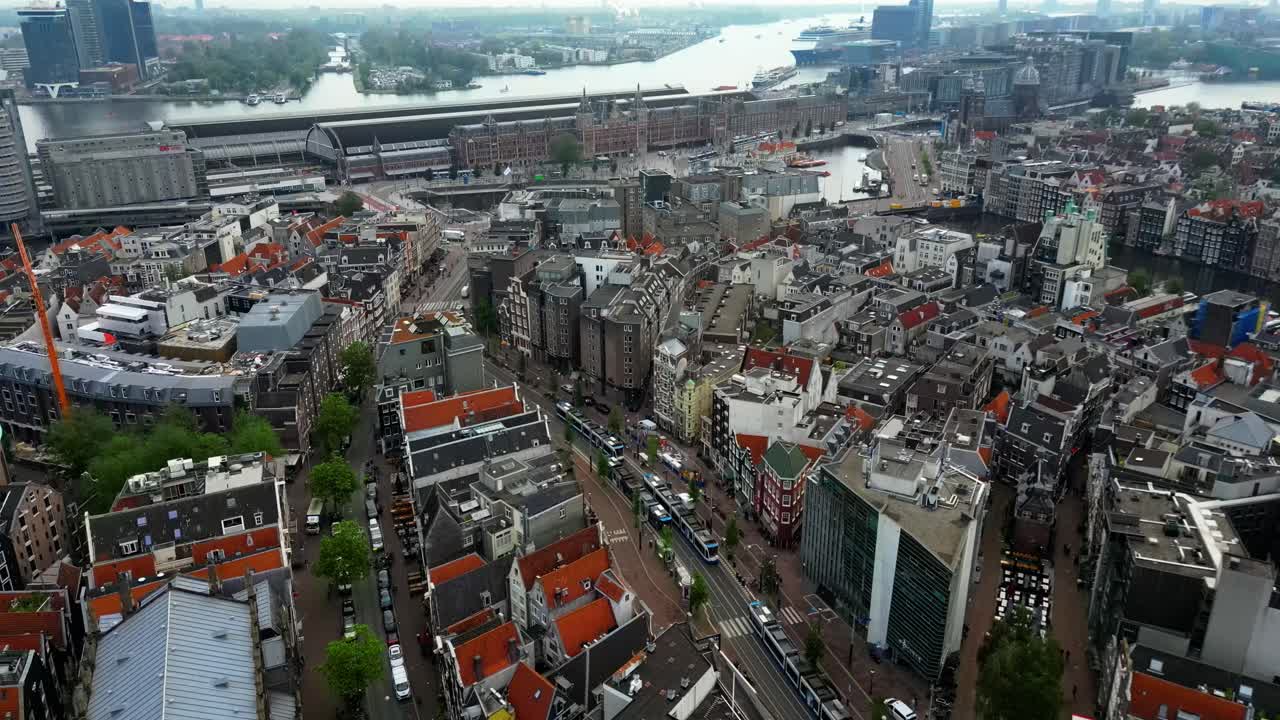 Drone tilts down while flying forward over busy Amsterdam streets (60fps)