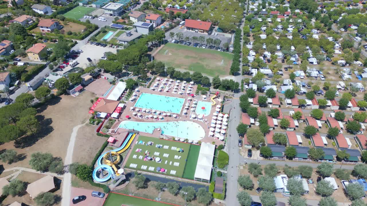 Ein riesiger Pool mit mehreren Wasserrutschen bildet den Mittelpunkt, umgeben von einem Wohnmobilpark