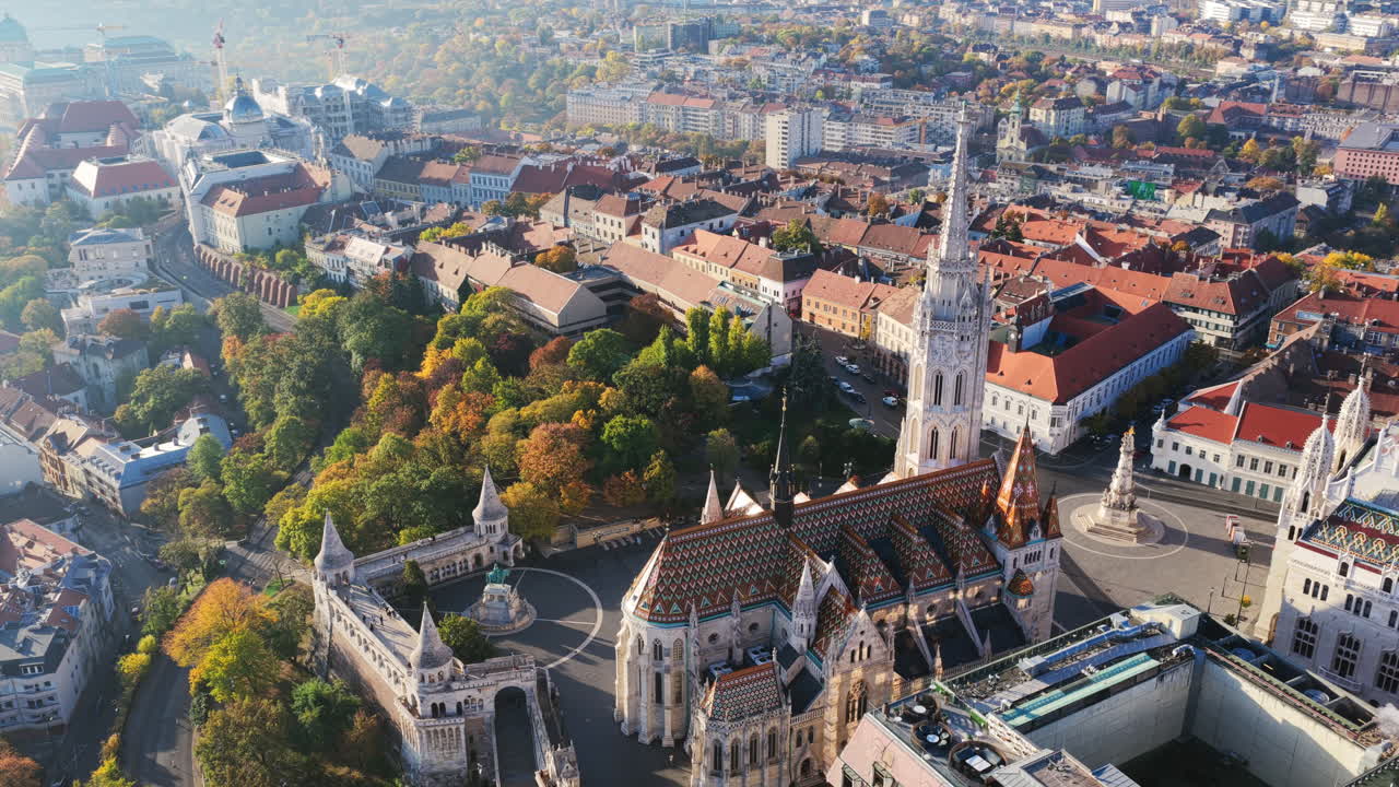 A stunning aerial view of Matthias Church and Fisherman’s Bastion surrounded by autumn trees and historic rooftops in Budapest’s Castle District