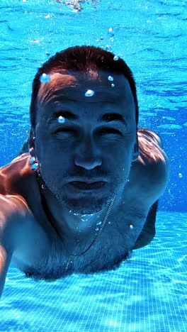 hombre nadando bajo el agua en una piscina