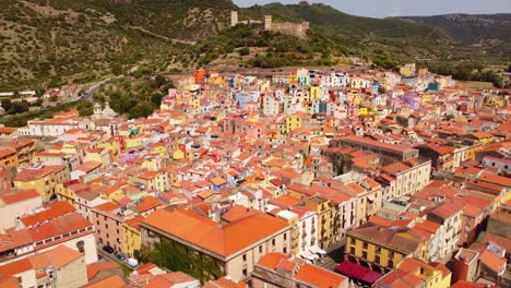 4K-Luftaufnahme-Der-Stadt-Bosa-Auf-Sardinien,-Bunte-Häuser,-Die-über-Dächern-Vorwärts-Fliegen