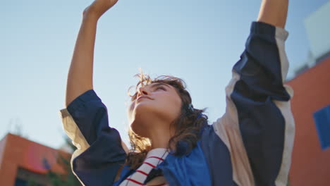 girl headphones dancing sunlight raising hands up closeup. woman listening music