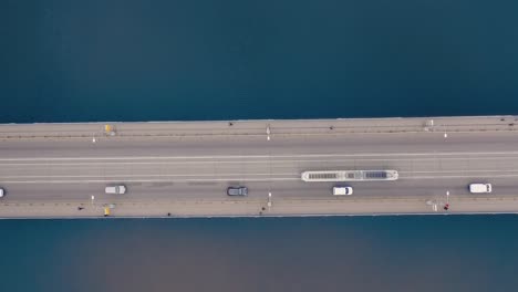 aerial shot bridge with tram, cars moving. drone flying over bridge with river, transport on a highway