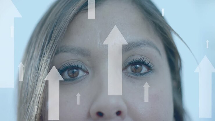 Upward data arrows over eyes of smiling biracial casual businesswoman in office