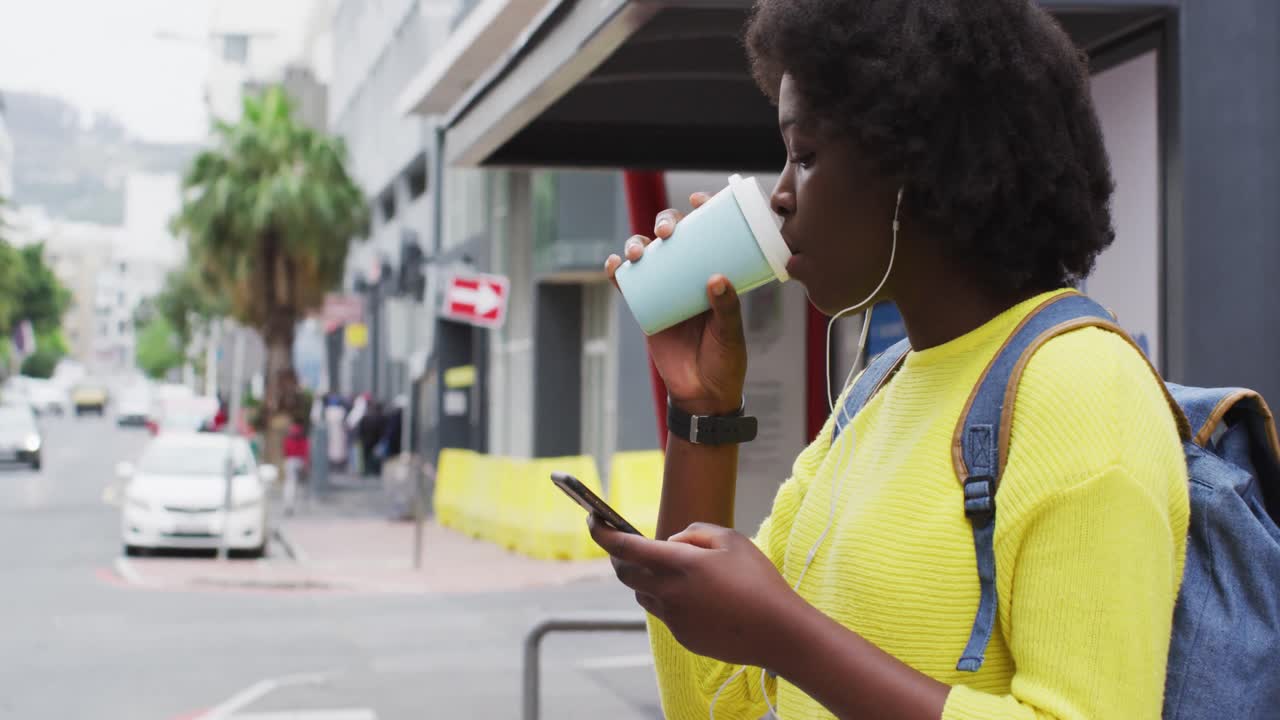 아프리카계 미국인이 거리에서 스마트폰을 사용하고 있습니다.