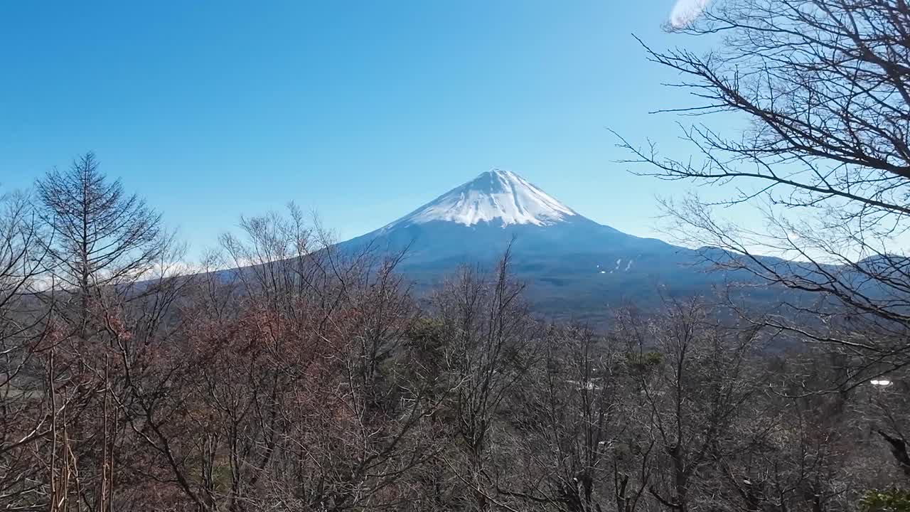Udsigt over Fuji-bjerget og dets sneklædte top fra et bjerg over for Fuji-bjerget på en skyfri dag i Japan.