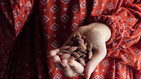 woman holding a handful of roasted almonds