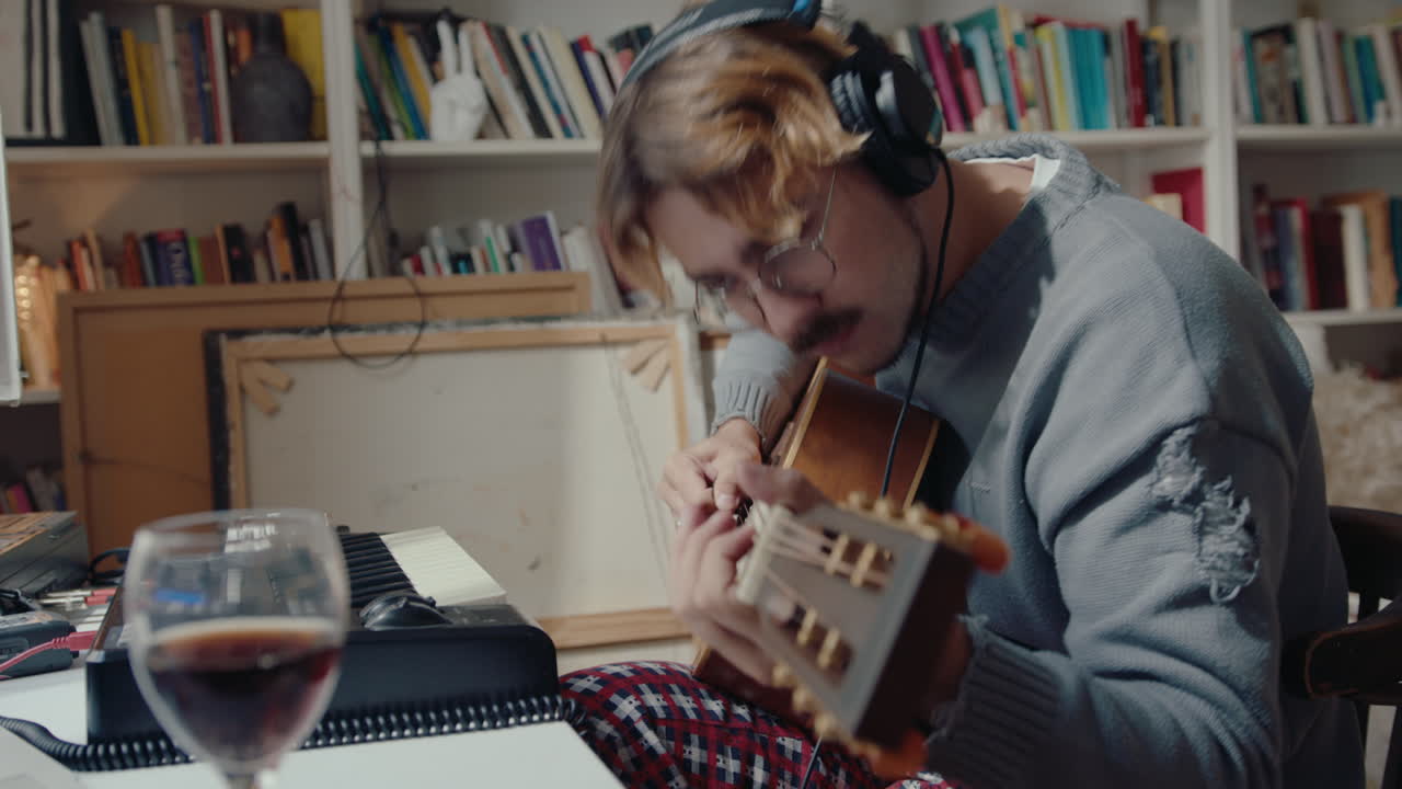 Musician Drinking Wine and Playing the Guitar at Home Studio