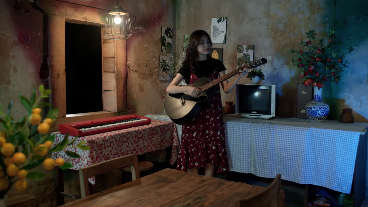 Cute Asian woman singing and playing guitar at home, Vintage home decor and interiors