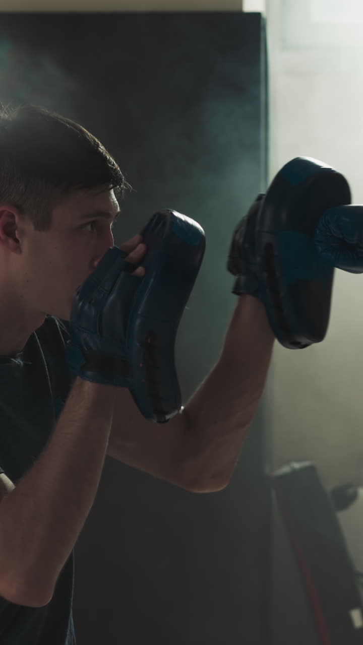 Kid punches glove pads exercising with trainer in gym. Martial arts instructor teaches little girl to attack in sports school slow motion. Healthy child