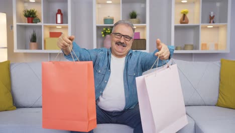 un anciano mostrando bolsas de compras a la cámara.