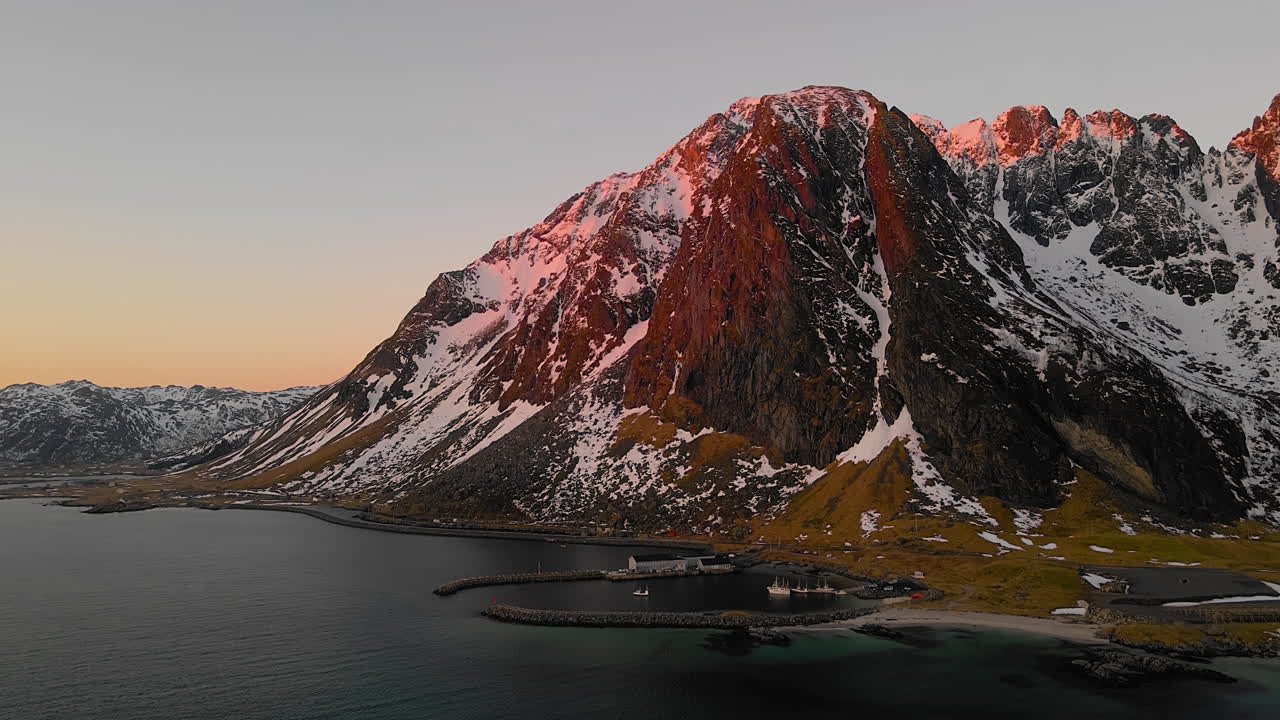 vista aérea del puerto deportivo con las montañas rocosas al amanecer en la playa de eggum, noruega
