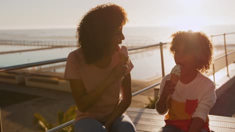 mother and son eating ice cream with sea in background