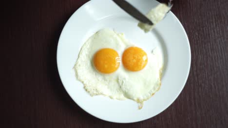 Fried-eggs-eating.-Top-view-of-fried-eggs-eating-with-fork-and-knife