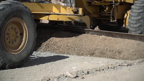 maquinaria de construcción que despeja y suaviza un camino de grava