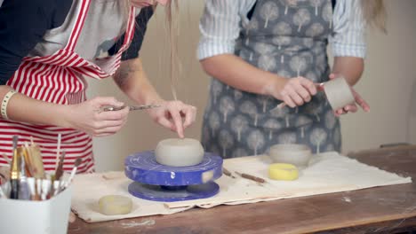 dos mujeres creando cerámica en una rueda de cerámica