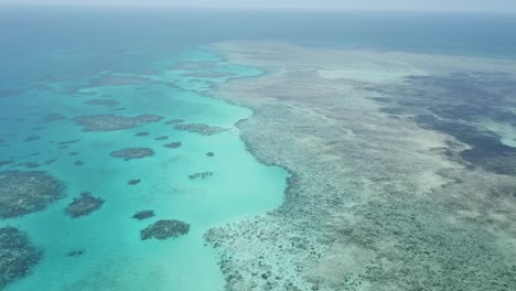 drone aerial pan up on the great barrier reef that has tropical blue water