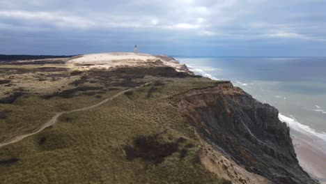 Aerial-view-of-Rubjerg-Knude-with-lighthouse-and-beautiful-coastline-by-the-North-Sea,-Denmark