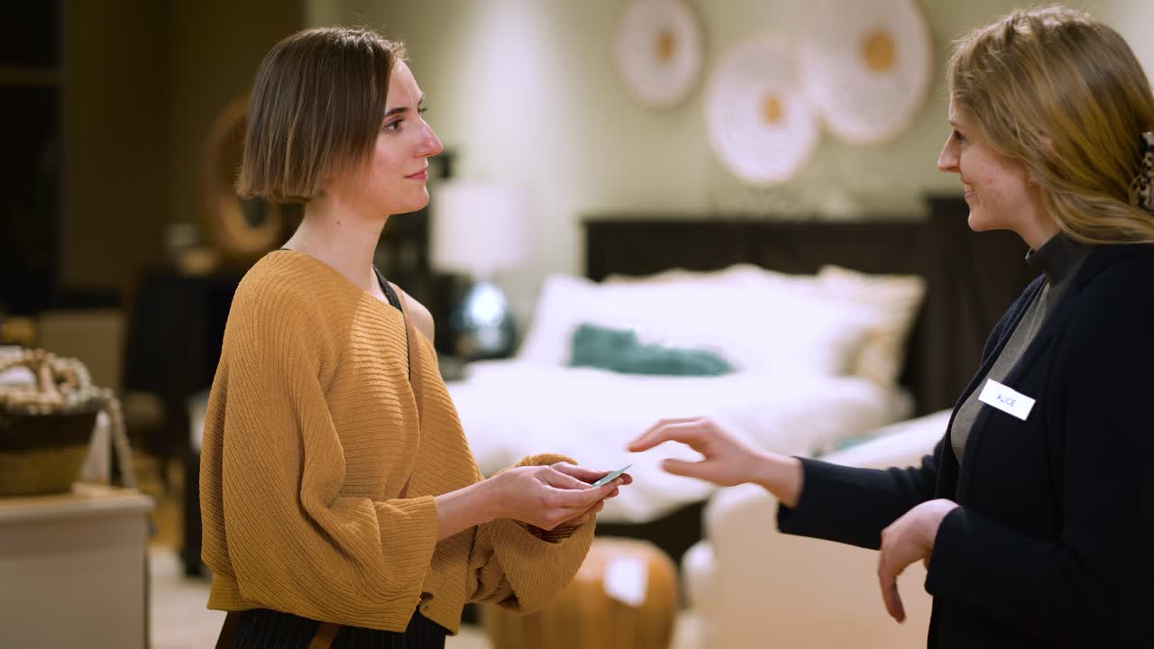 A Female Sales Associate Gives a Customer Her Business Card