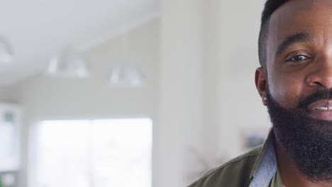 Half-face-portrait-of-happy-bearded-african-american-man-smiling,-with-copy-space,-slow-motion