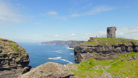 Luftaufnahmen-Der-Klippen-Von-Moher-Hinter-Einem-Felsen,-Auf-Dem-Sich-Der-Moher-Turm-Befindet