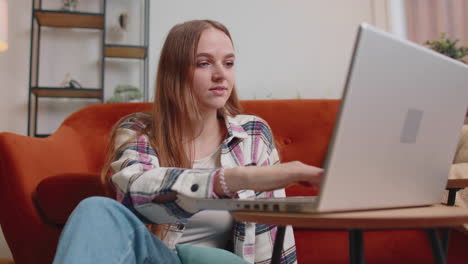 Mujer-Joven-Usando-Una-Computadora-Portátil-Sentada-En-El-Piso-Trabajando,-Comprando-En-Línea-Desde-La-Oficina-En-Casa