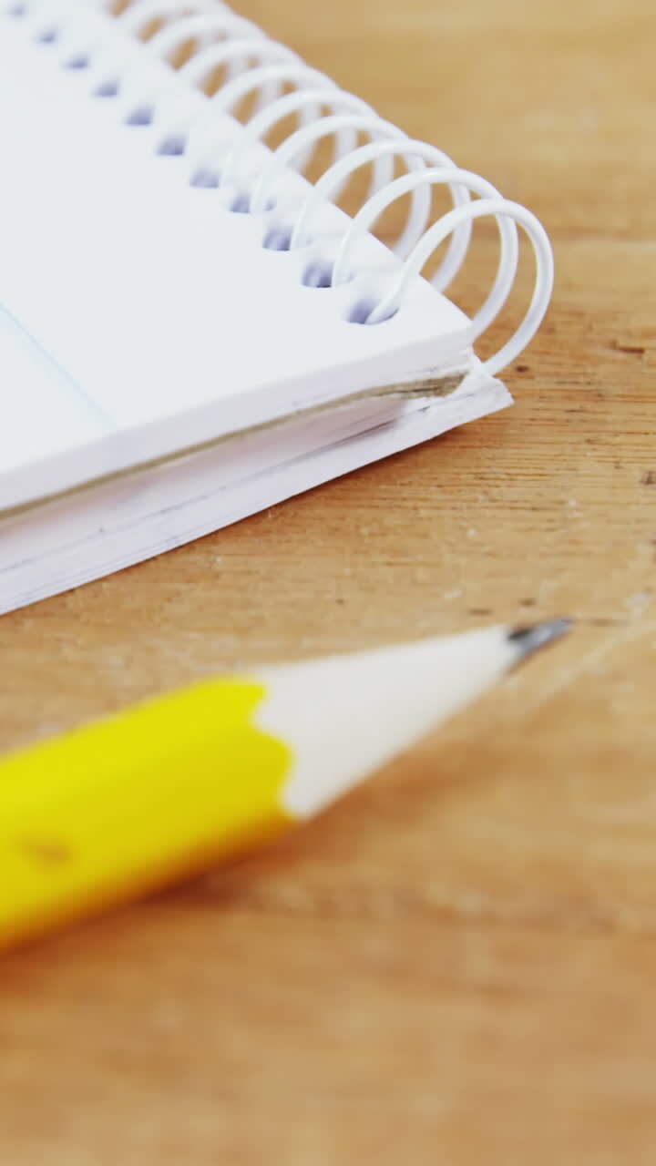Notepad and pencil on wooden plank