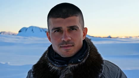 man smiling in snowy mountain landscape