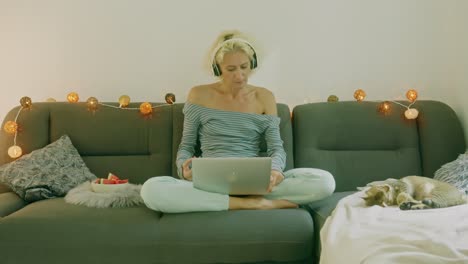 mujer trabajando desde casa en el sofá