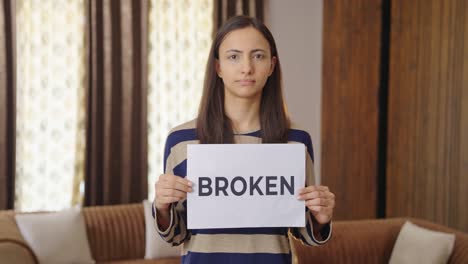 sad indian woman holding broken banner