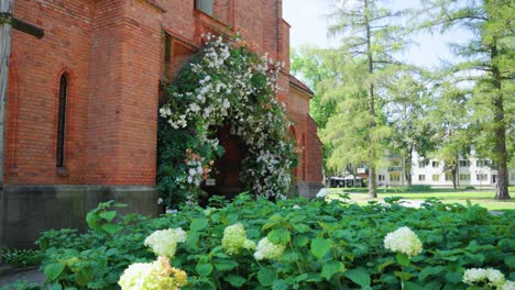 Shot of main entrance of the Catholic church of Saint Mary&#039;s Scapular decorated with white flowers and greenery in Druskininkai, Lithuania