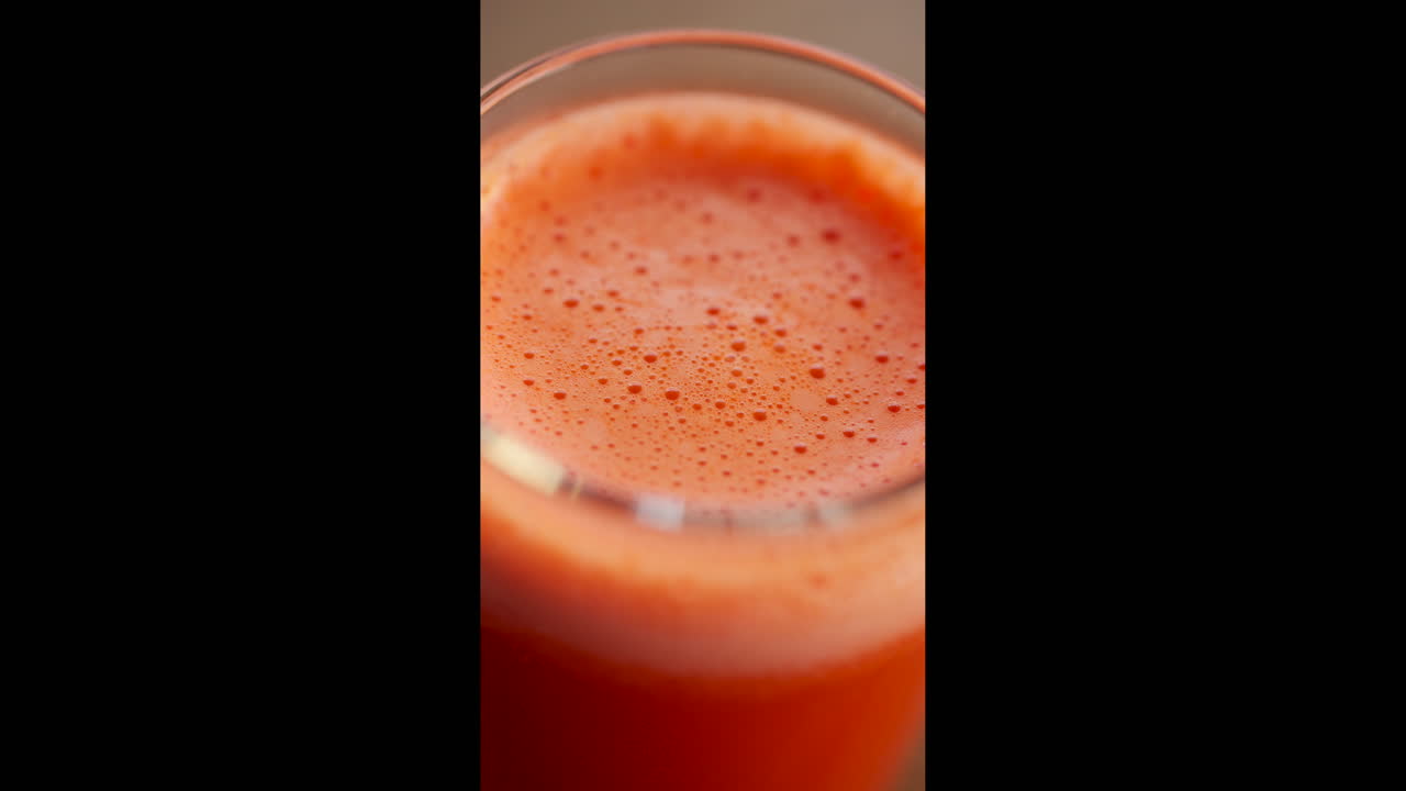 Primo piano estremo della superficie di succo d'arancia fresco con bolle e schiuma