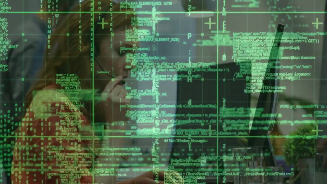 Woman wearing headset typing and speaking at desk, causing green overlay while taking business call