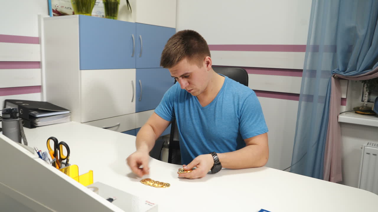 Man considers coins bitcoin. Cryptocurrency concept. Gold bitcoin in the hand of man. Digital symbol of the new virtual currency.