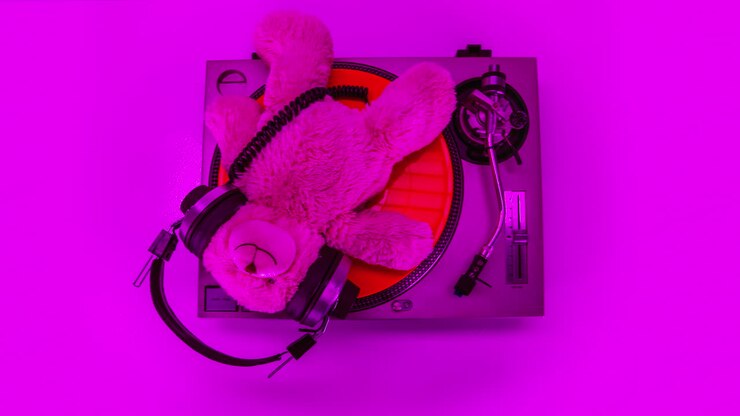 Orsetto di peluche rosa che fa il DJ su un giradischi