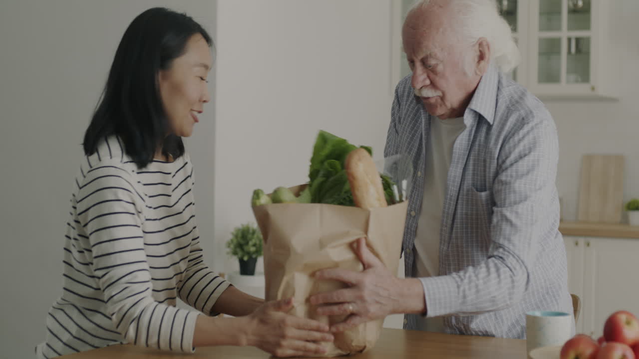 Daughter Helping Elderly Father with Groceries