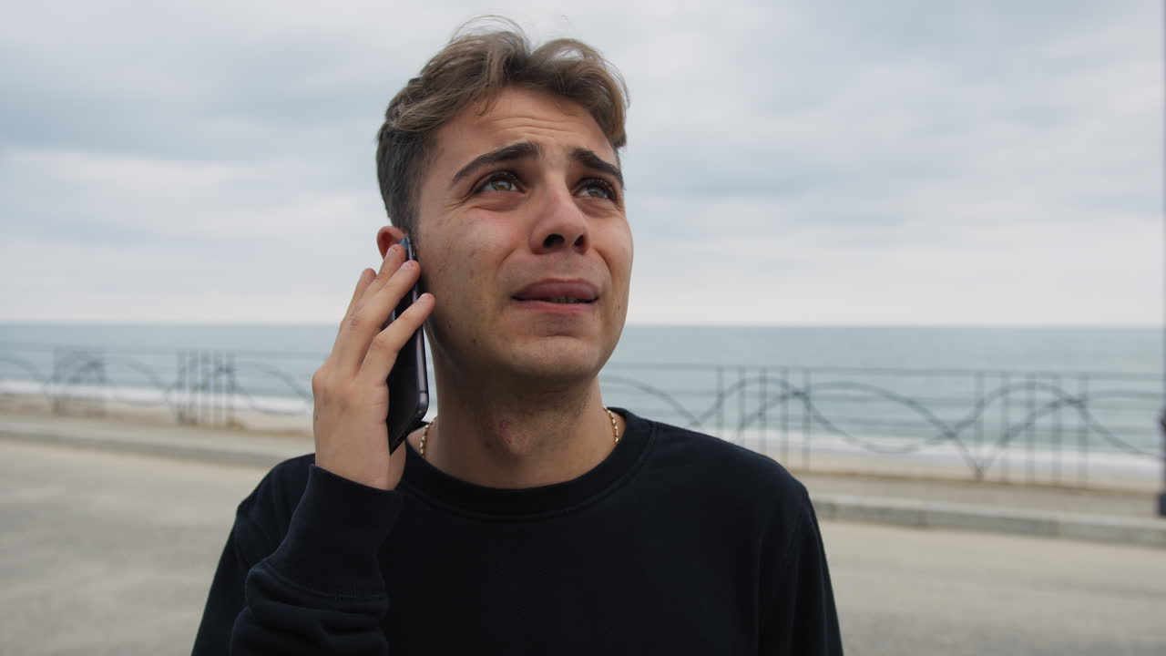 el niño recibe malas noticias por teléfono y se desespera tristemente al aire libre.