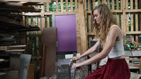 beautiful woman on makeshift upcycled fitness bike turned into repurposed sustainable carbon neutral food mixer on human power, blender inside shed